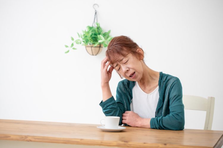 視床出血による頭痛に苦しむ高齢女性