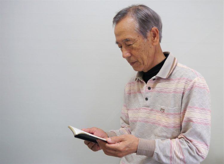 脳梗塞の後遺症による認知機能の低下に悩む手帳を見るシニア男性