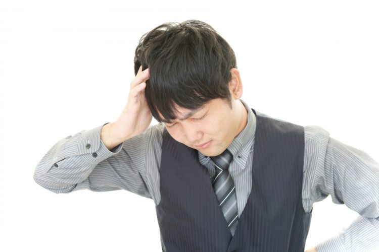 脳梗塞による頭痛に苦しむ男性サラリーマン